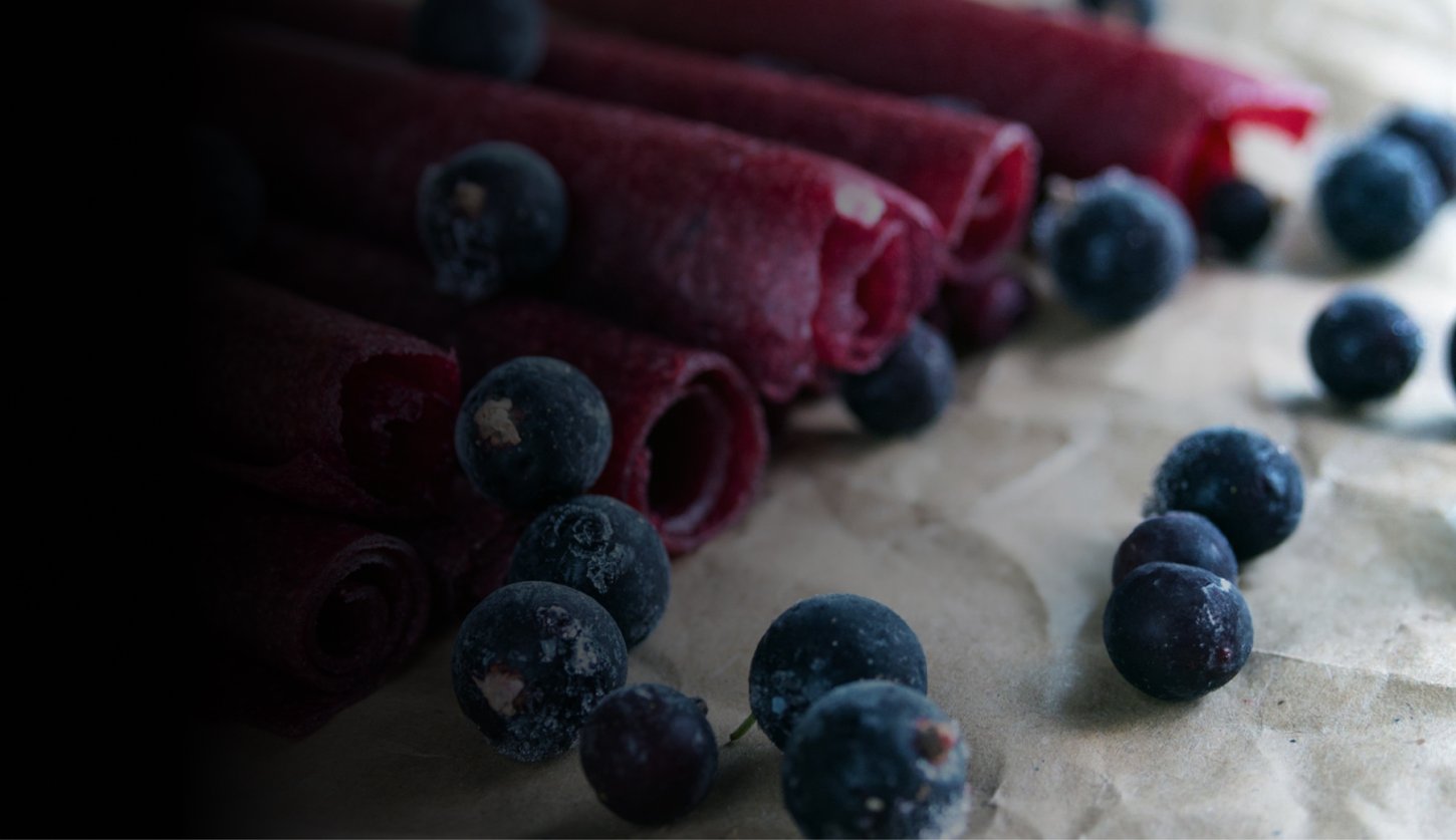 Pink fruit roll up snacks with blueberries.